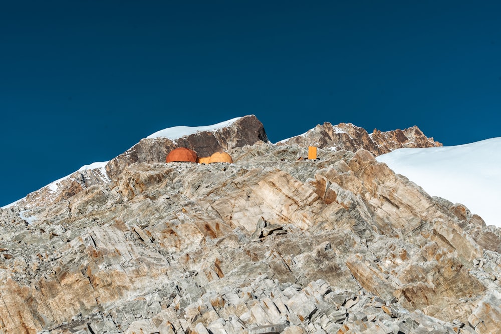 a couple of tents sitting on top of a snow covered mountain