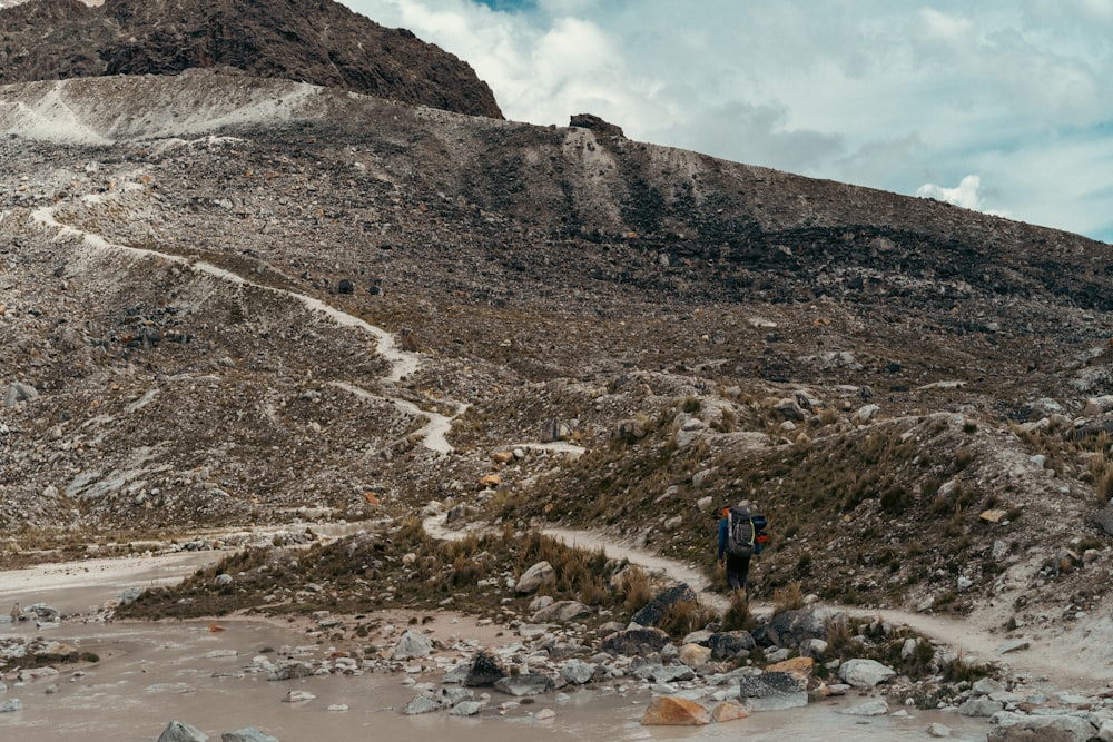 a man hiking up a rocky mountain trail