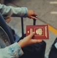 a person holding a red passport in their hand