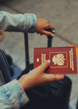 a person holding a red passport in their hand