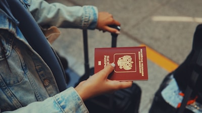 a person holding a red passport in their hand