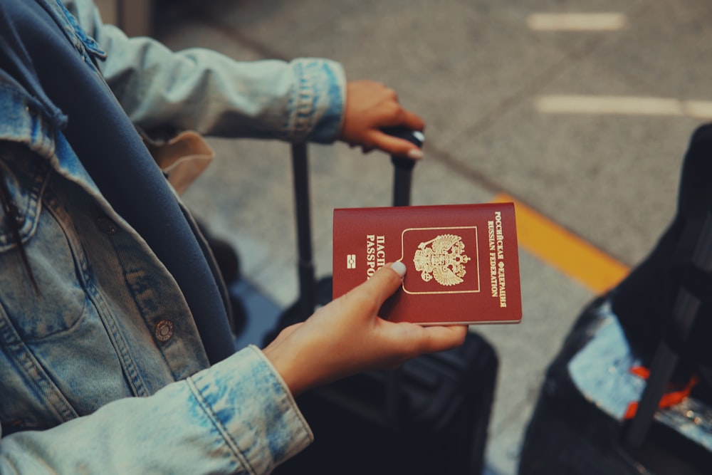 a person holding a red passport in their hand