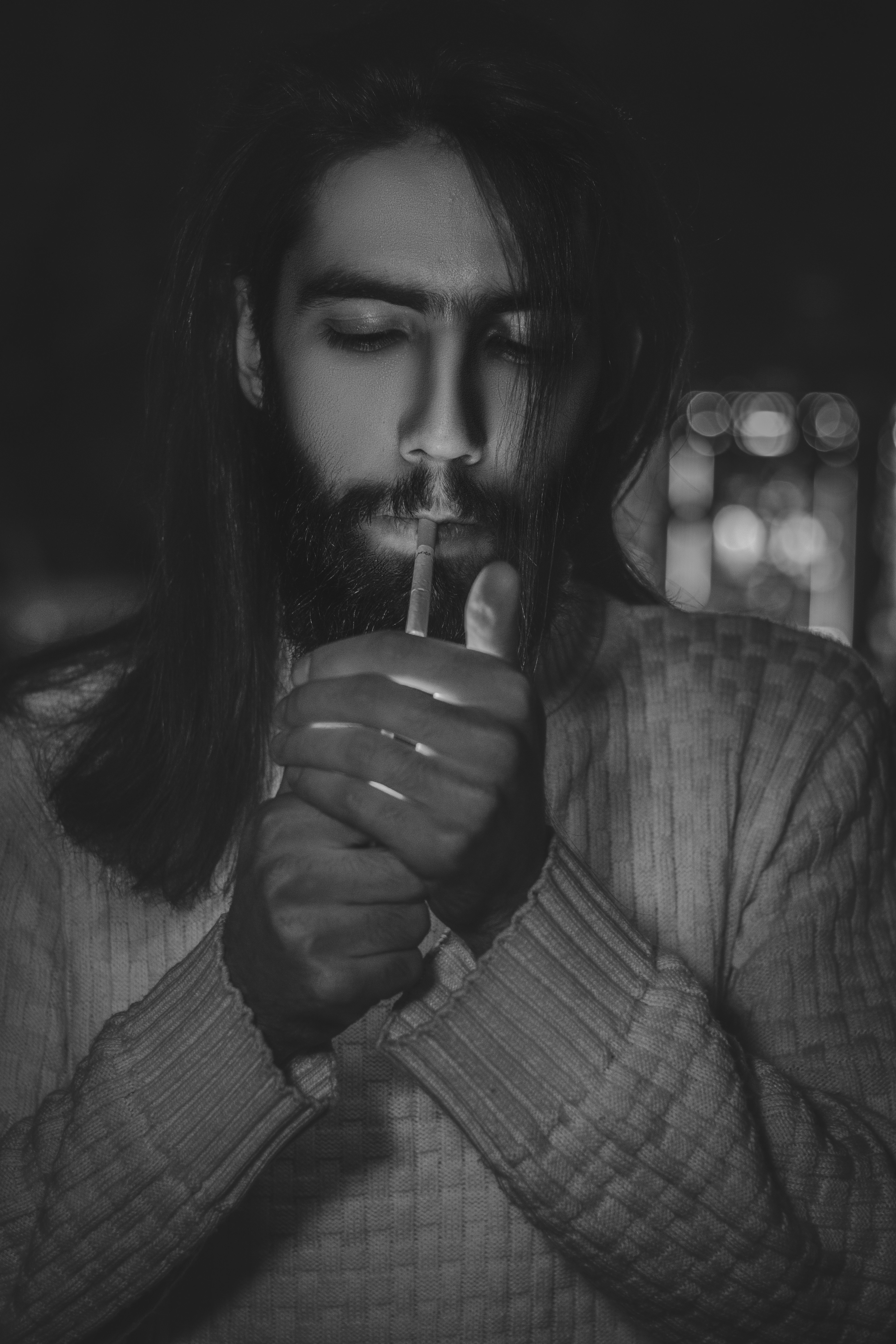 Un hombre con el pelo largo sosteniendo un cigarrillo