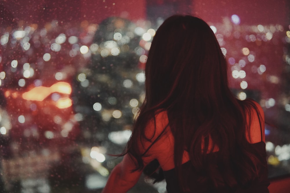 a woman looking out a window at a cityscape