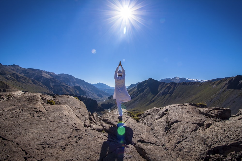 a person standing on top of a mountain with their arms in the air