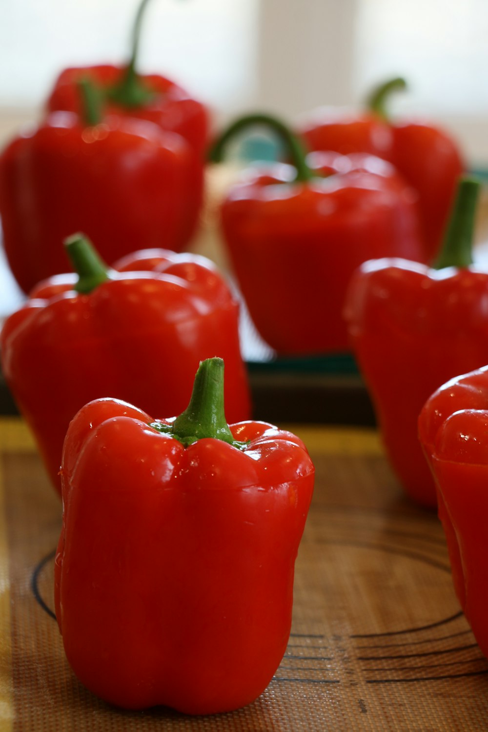 a group of red peppers sitting on top of a wooden table