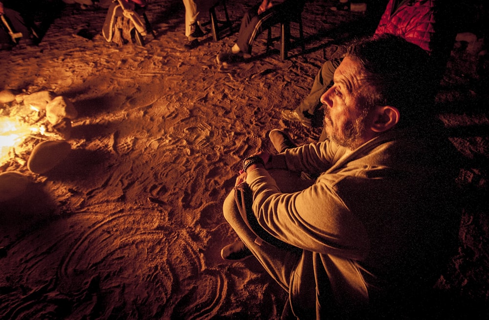 a man sitting in front of a campfire