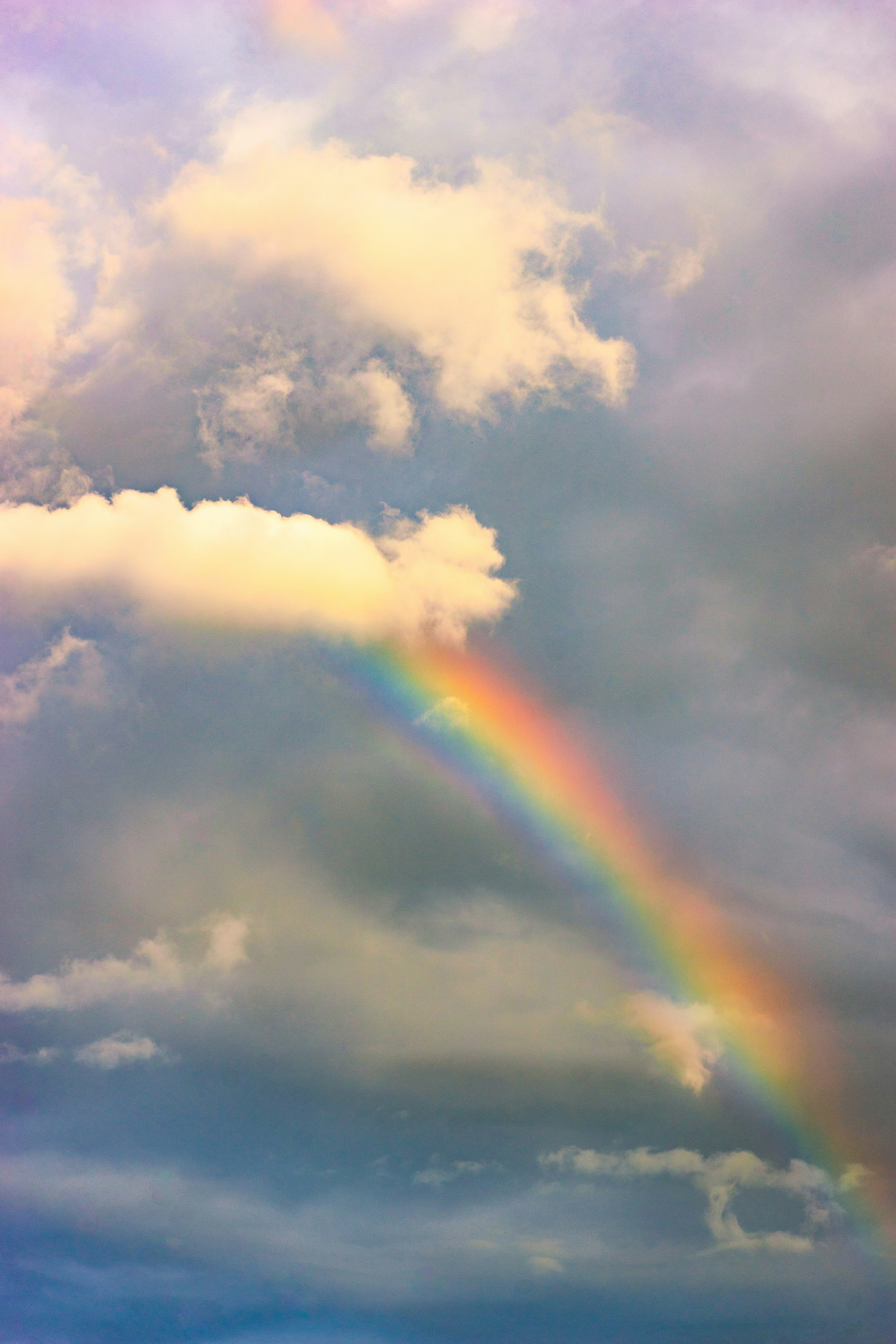 a rainbow in the sky with clouds in the background