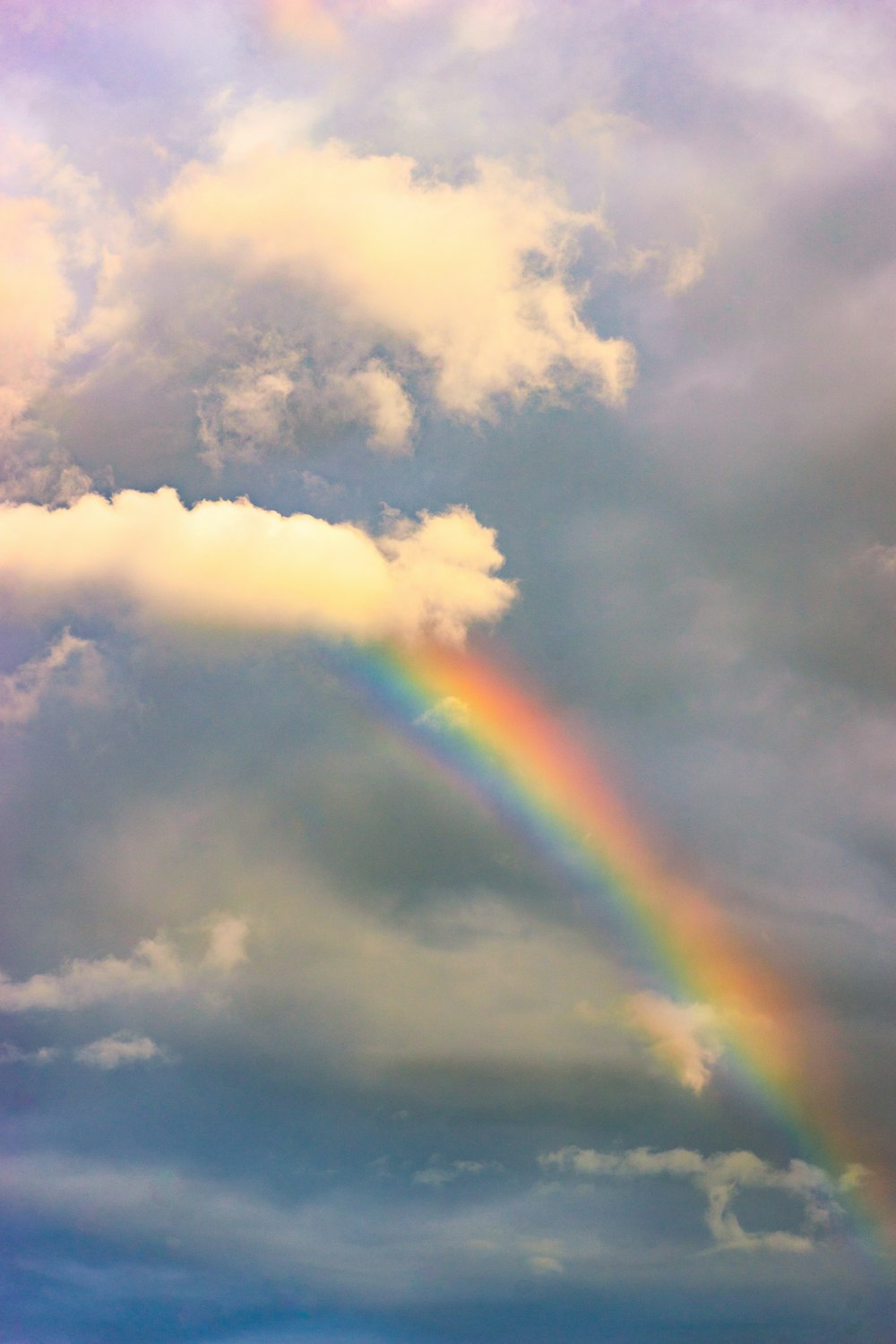 a rainbow in the sky with clouds in the background