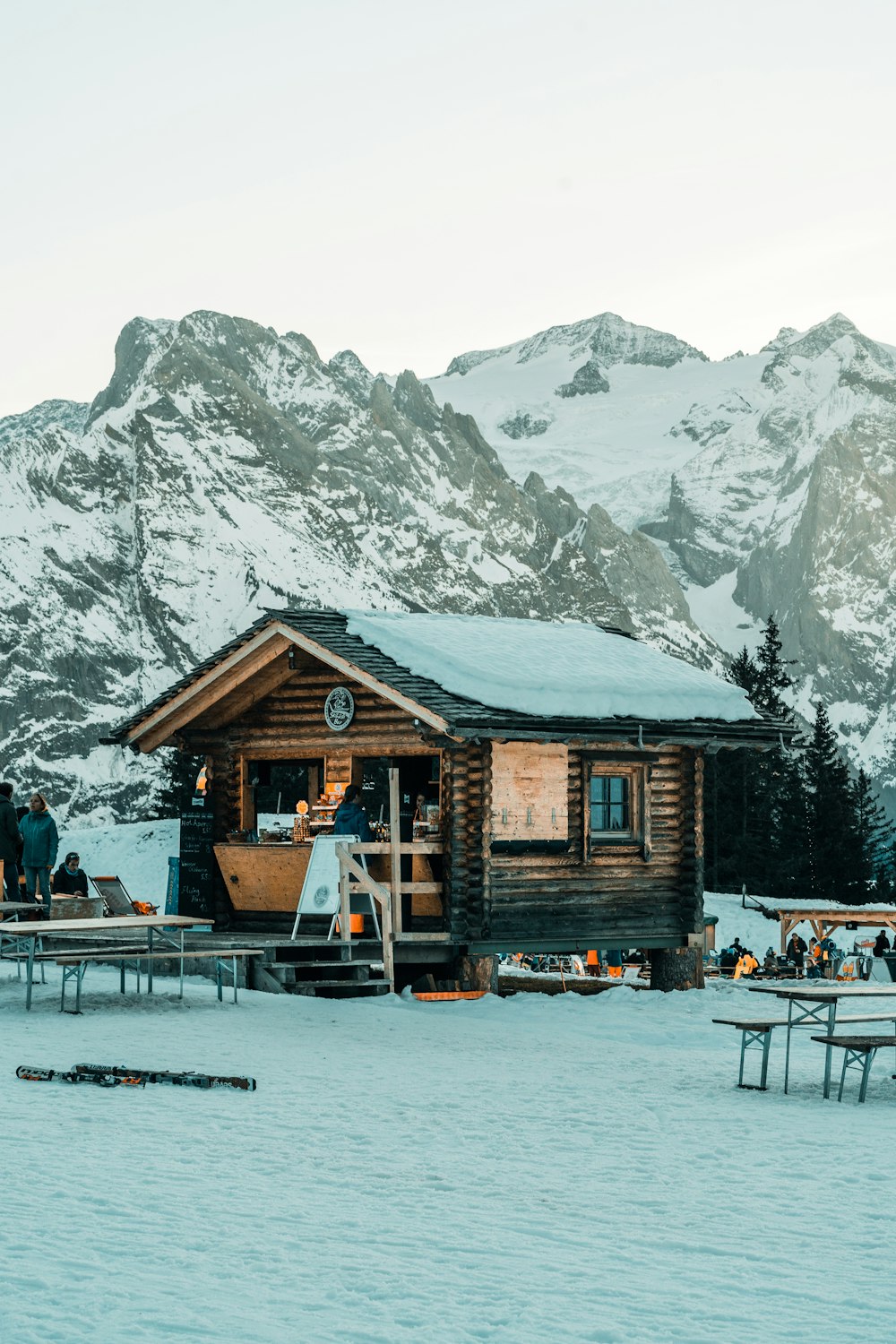 a group of people standing outside of a log cabin