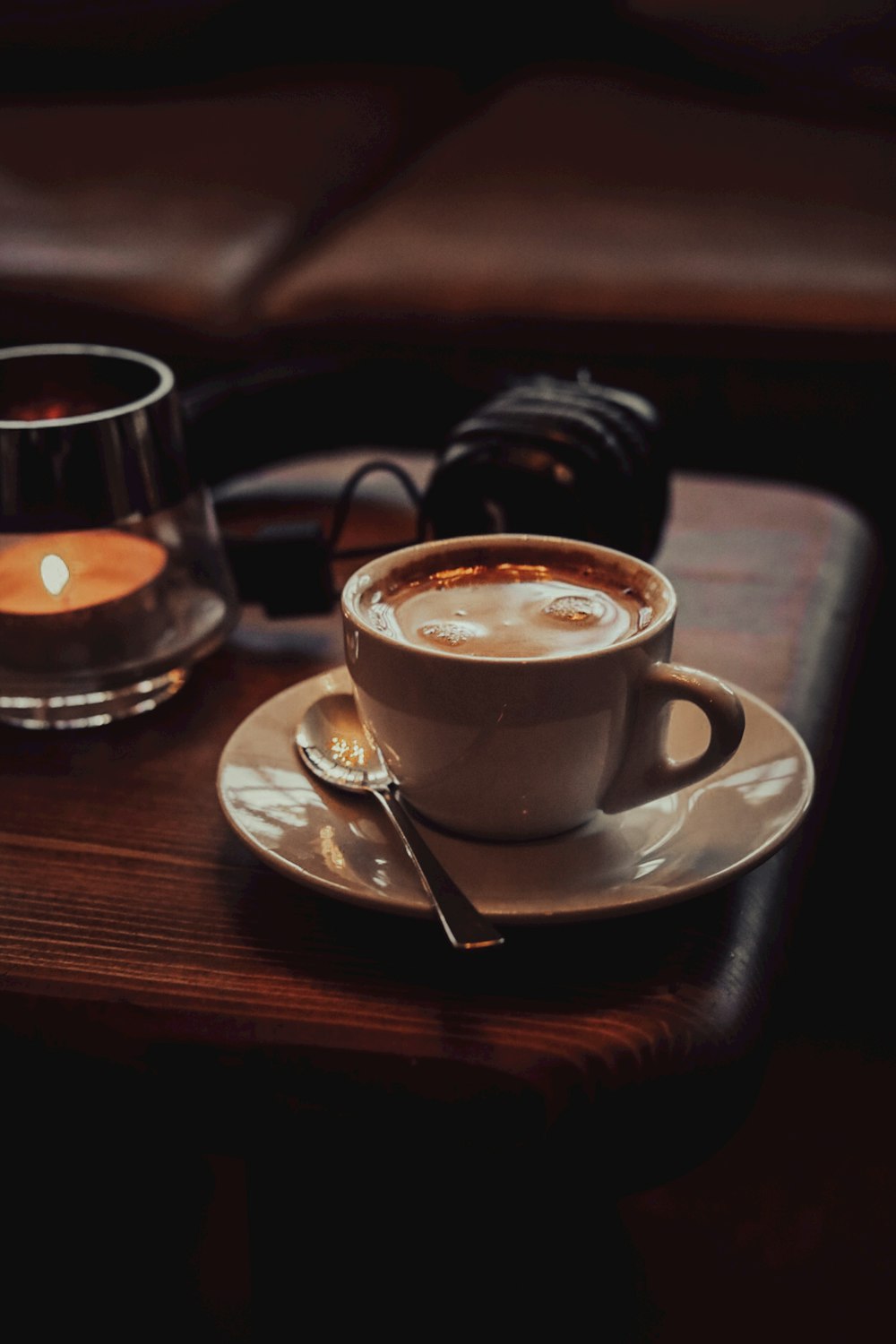 a cup of coffee sitting on top of a wooden table