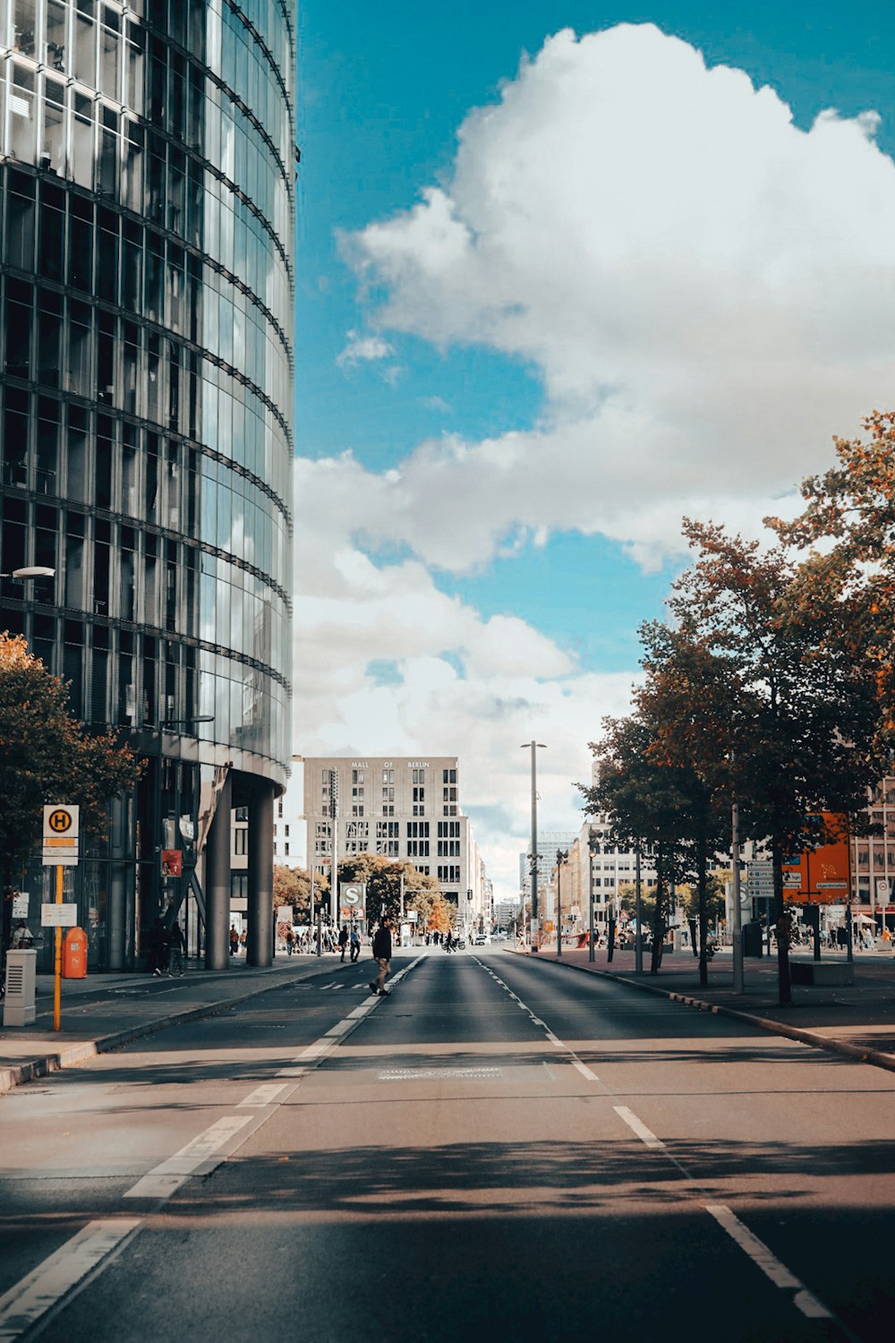 Eine Stadtstraße mit hohen Gebäuden unter einem bewölkt blauen Himmel