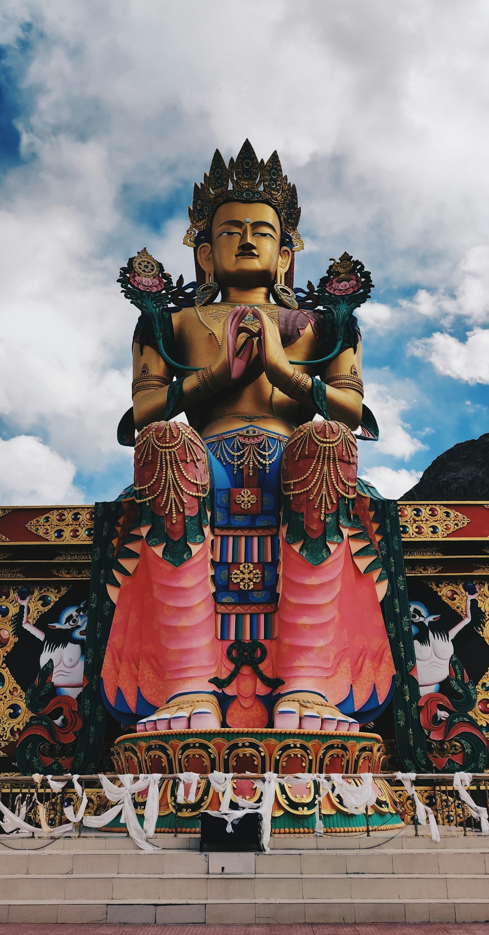 a large statue of a buddha sitting on top of a building