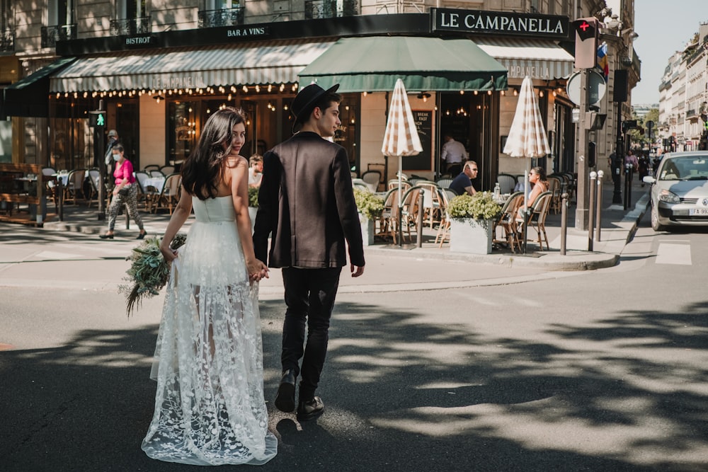 a bride and groom are walking down the street