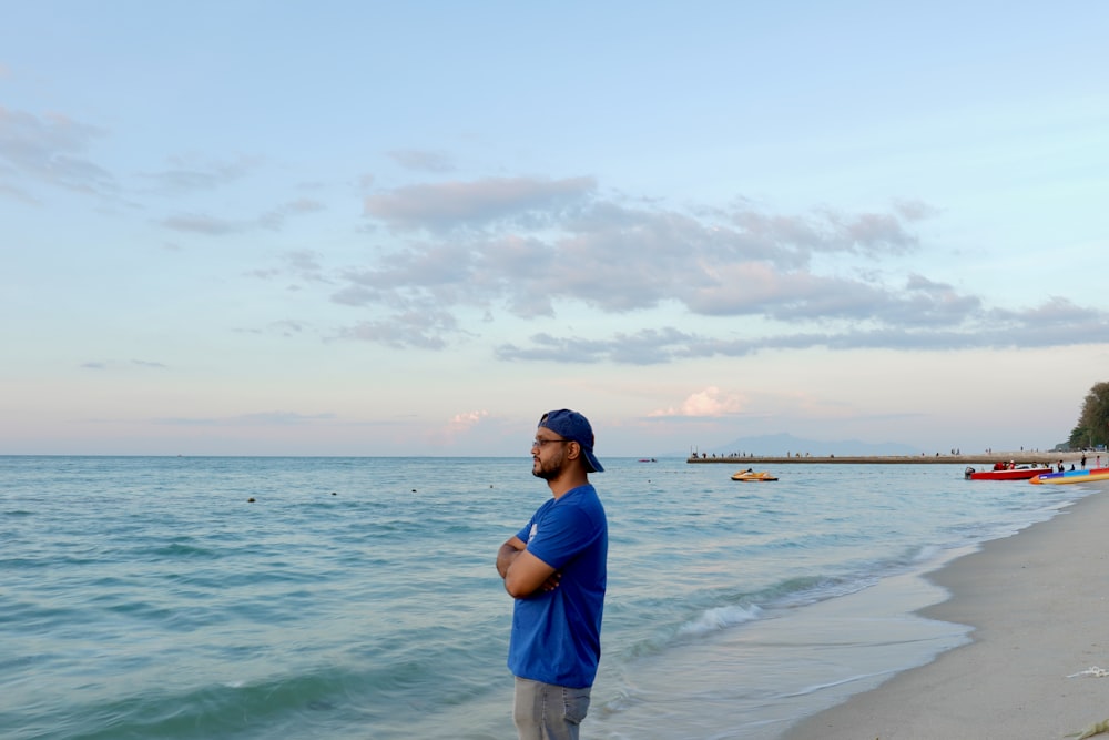 a man standing on a beach next to the ocean