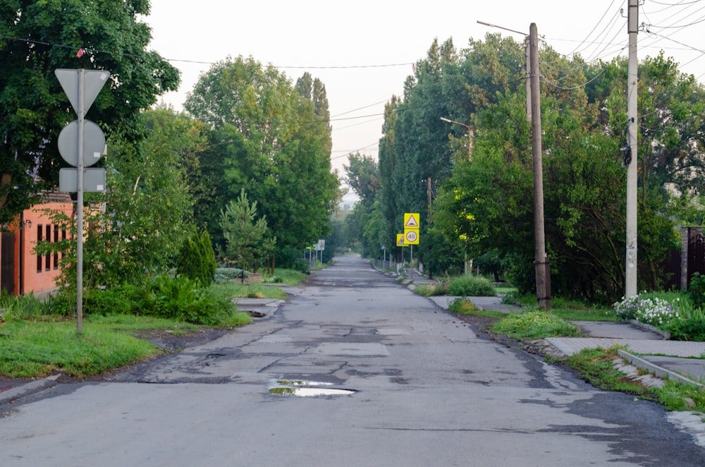 an empty street with a yellow sign on the side of it