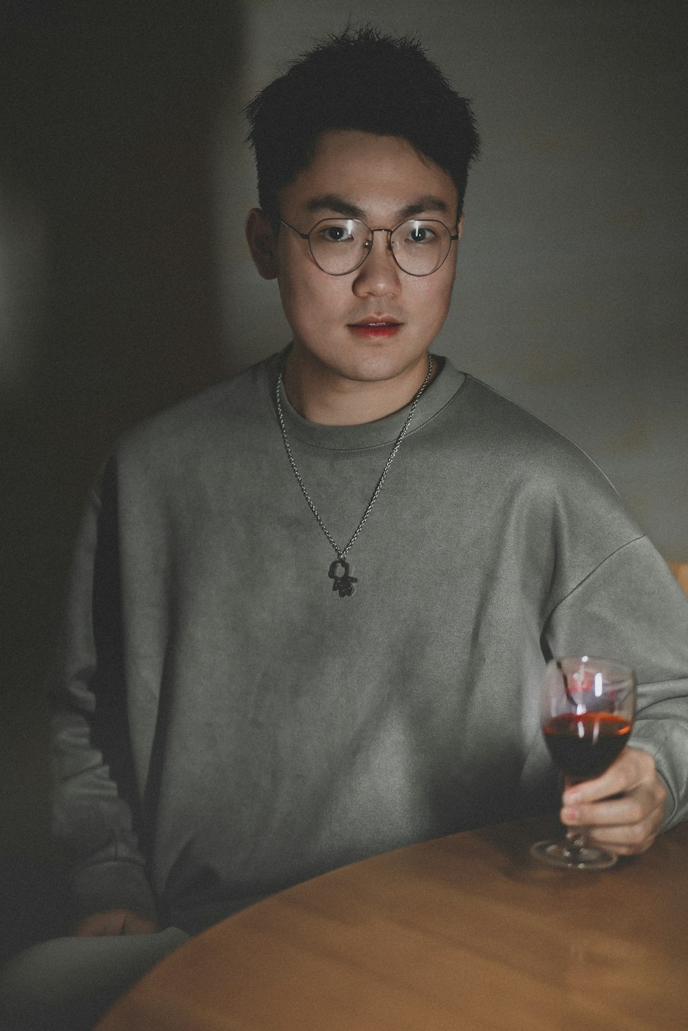 a man sitting at a table holding a glass of wine