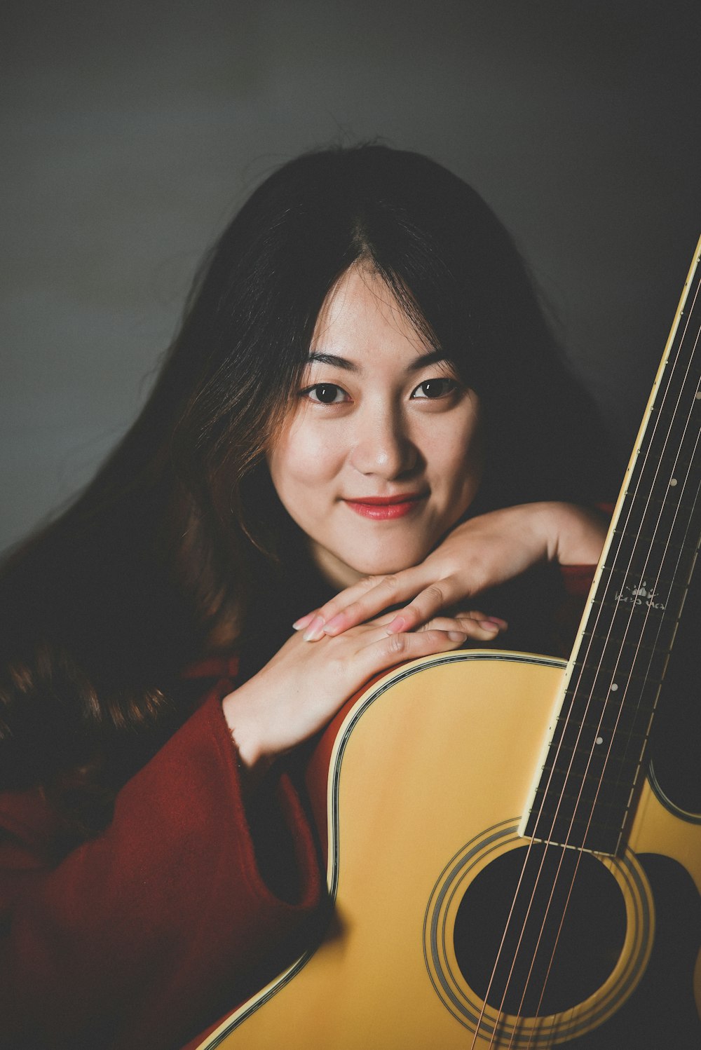 a woman holding a guitar in her hands