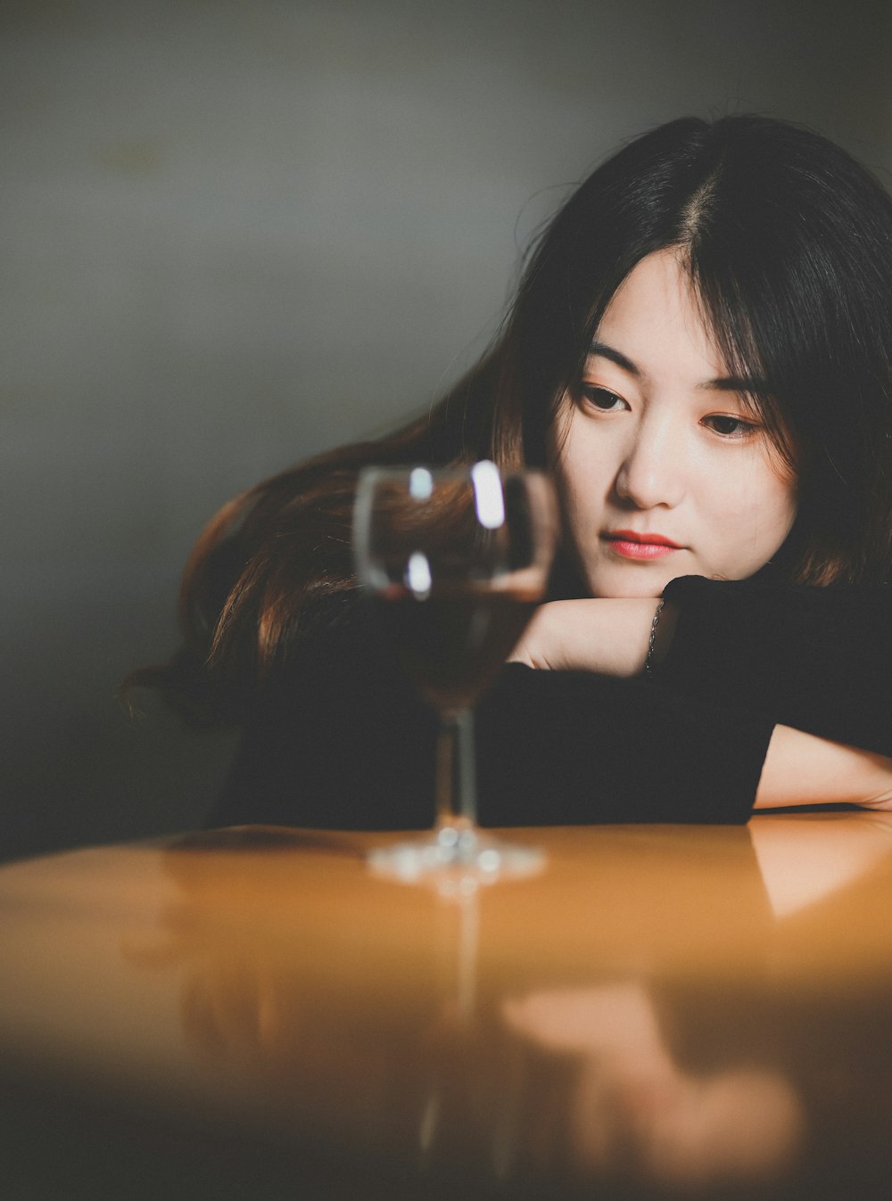 a woman sitting at a table with a glass of wine