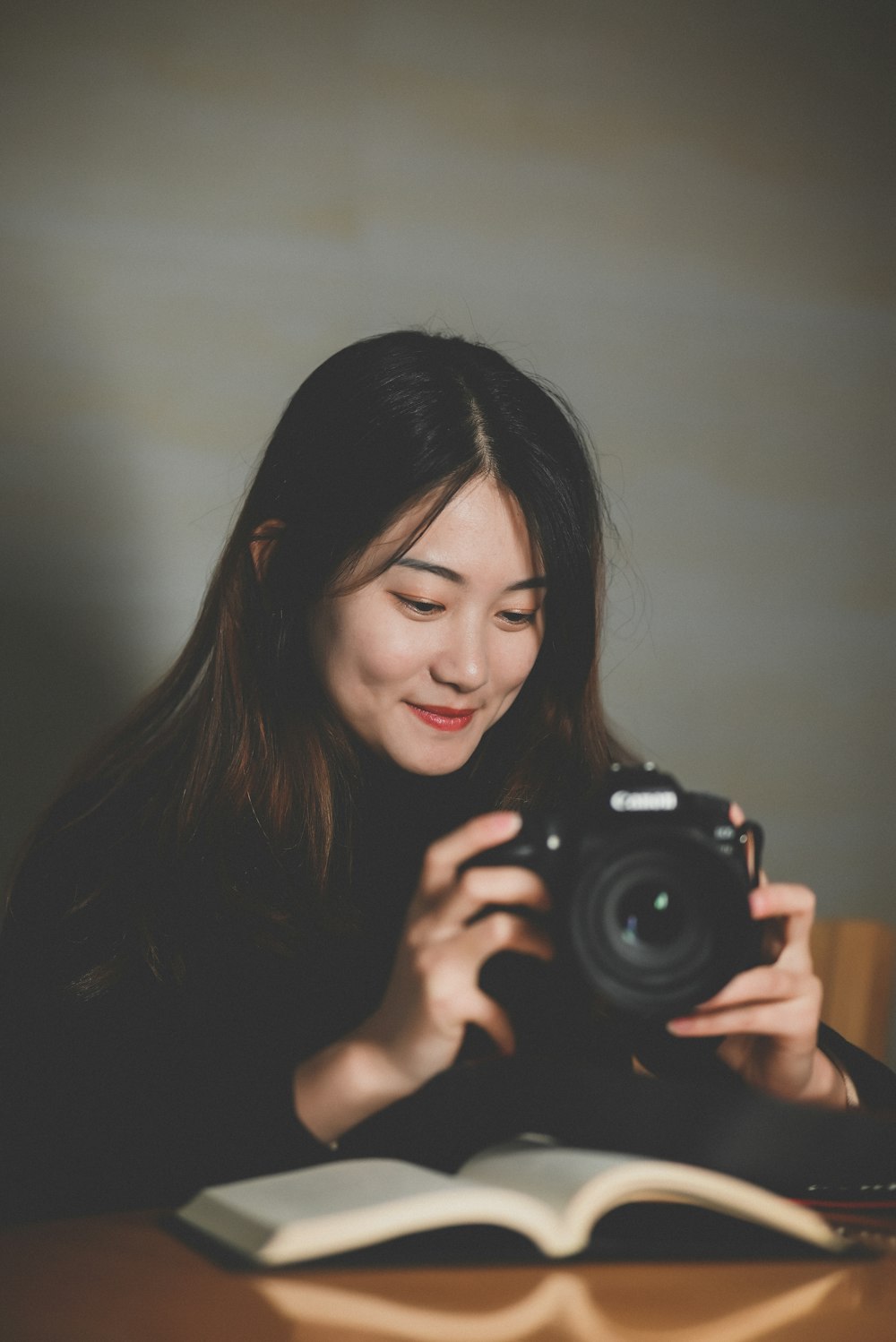 a woman taking a picture of a book with a camera