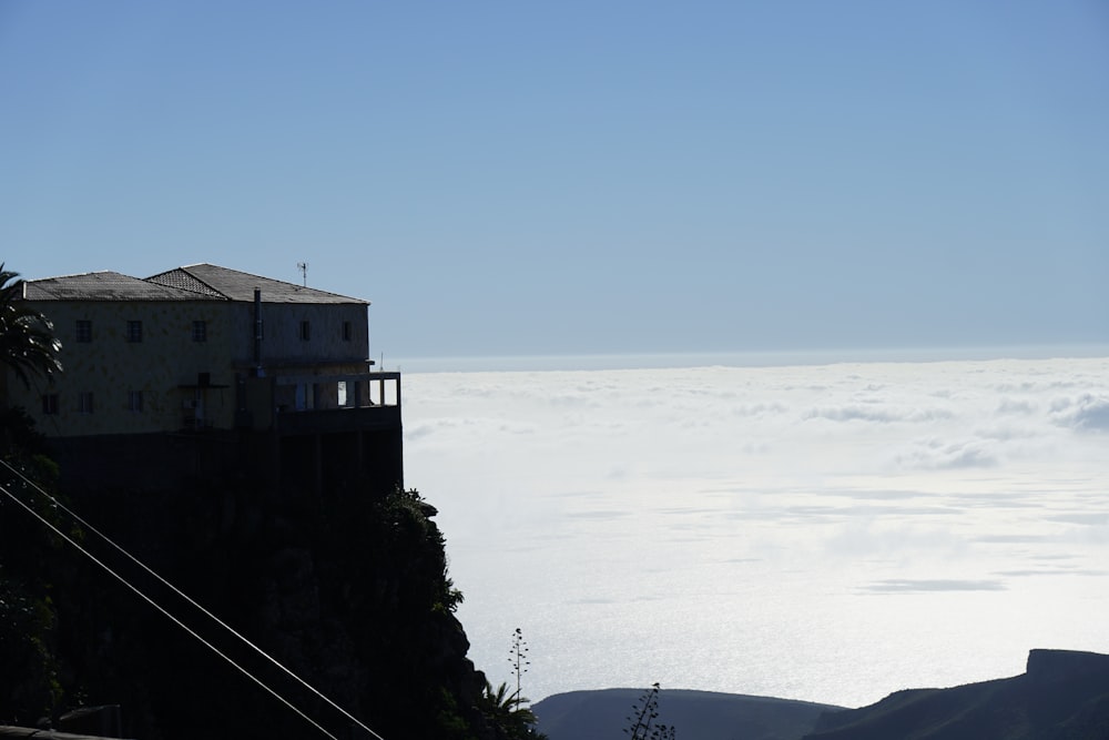 a house on a cliff above the clouds