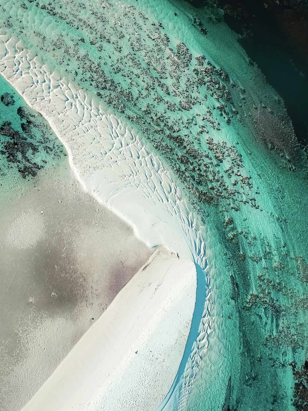 an aerial view of a sandy beach and water