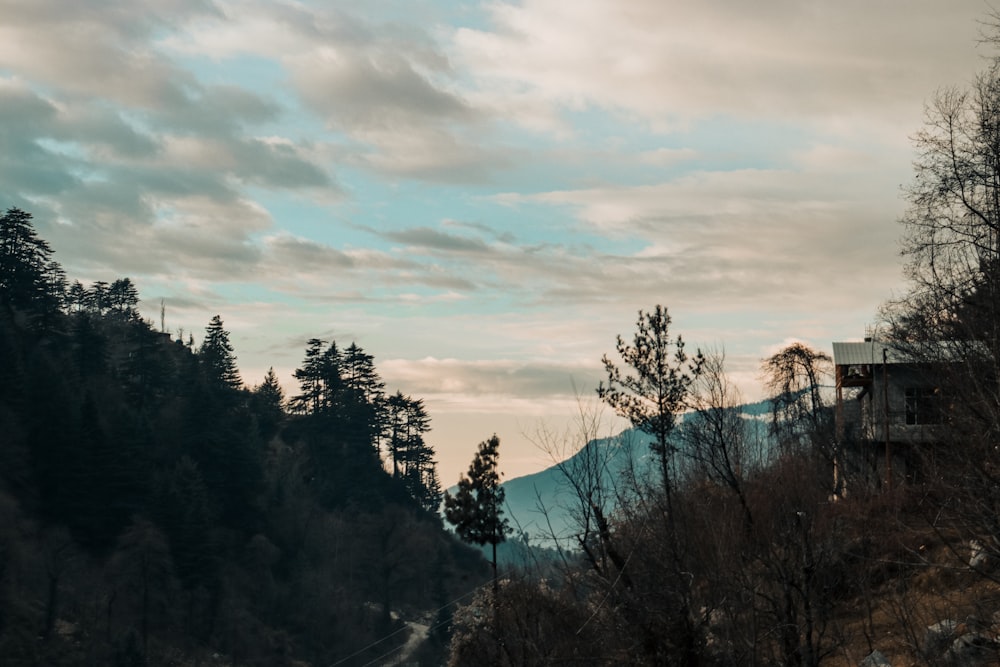 a scenic view of a mountain with a house in the distance