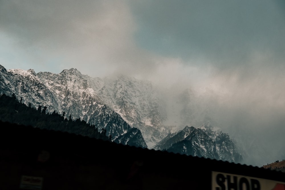 a mountain covered in snow under a cloudy sky