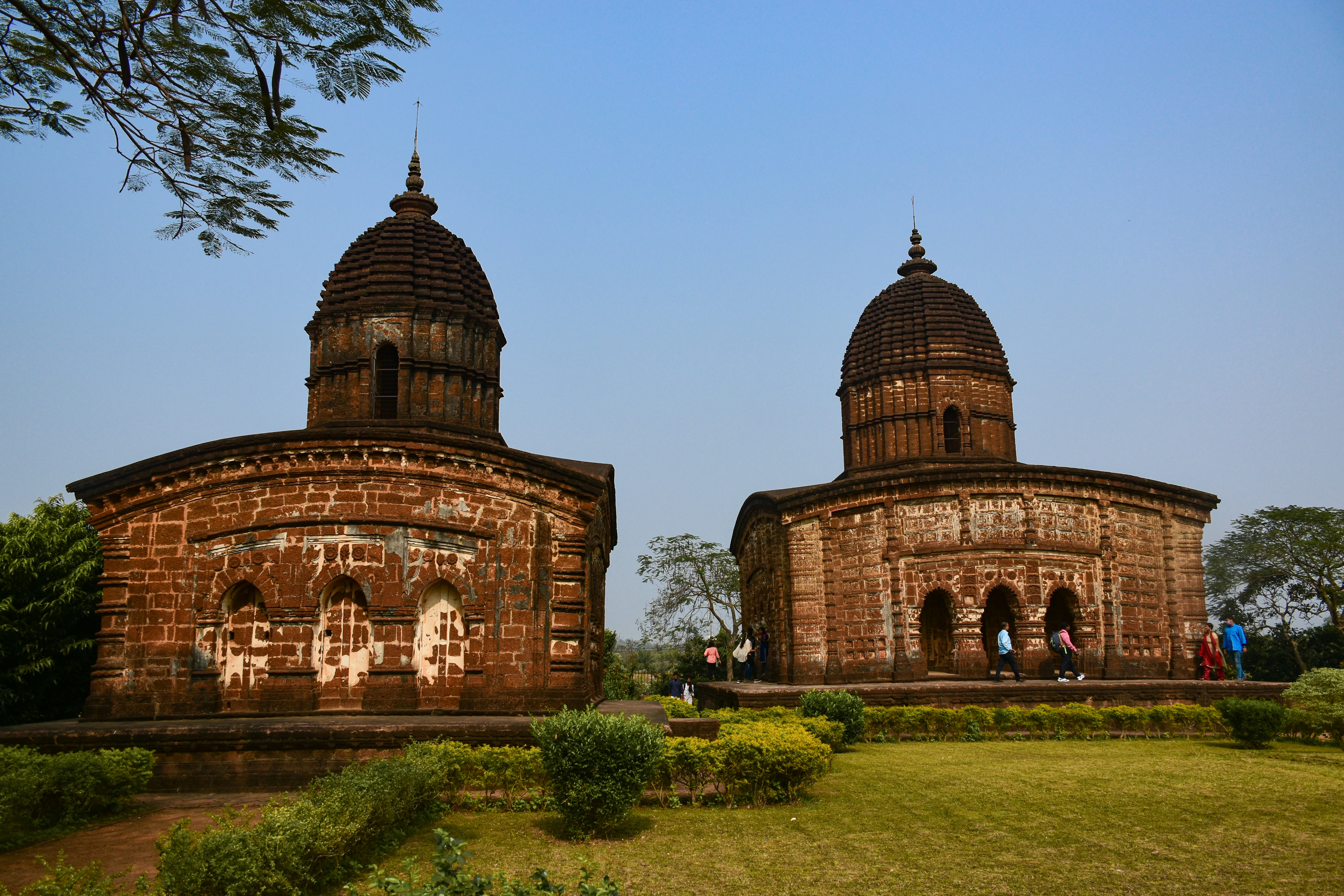 a couple of large brick buildings sitting on top of a lush green field