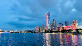 A city skyline at dusk with red and blue lights reflecting financial stability.