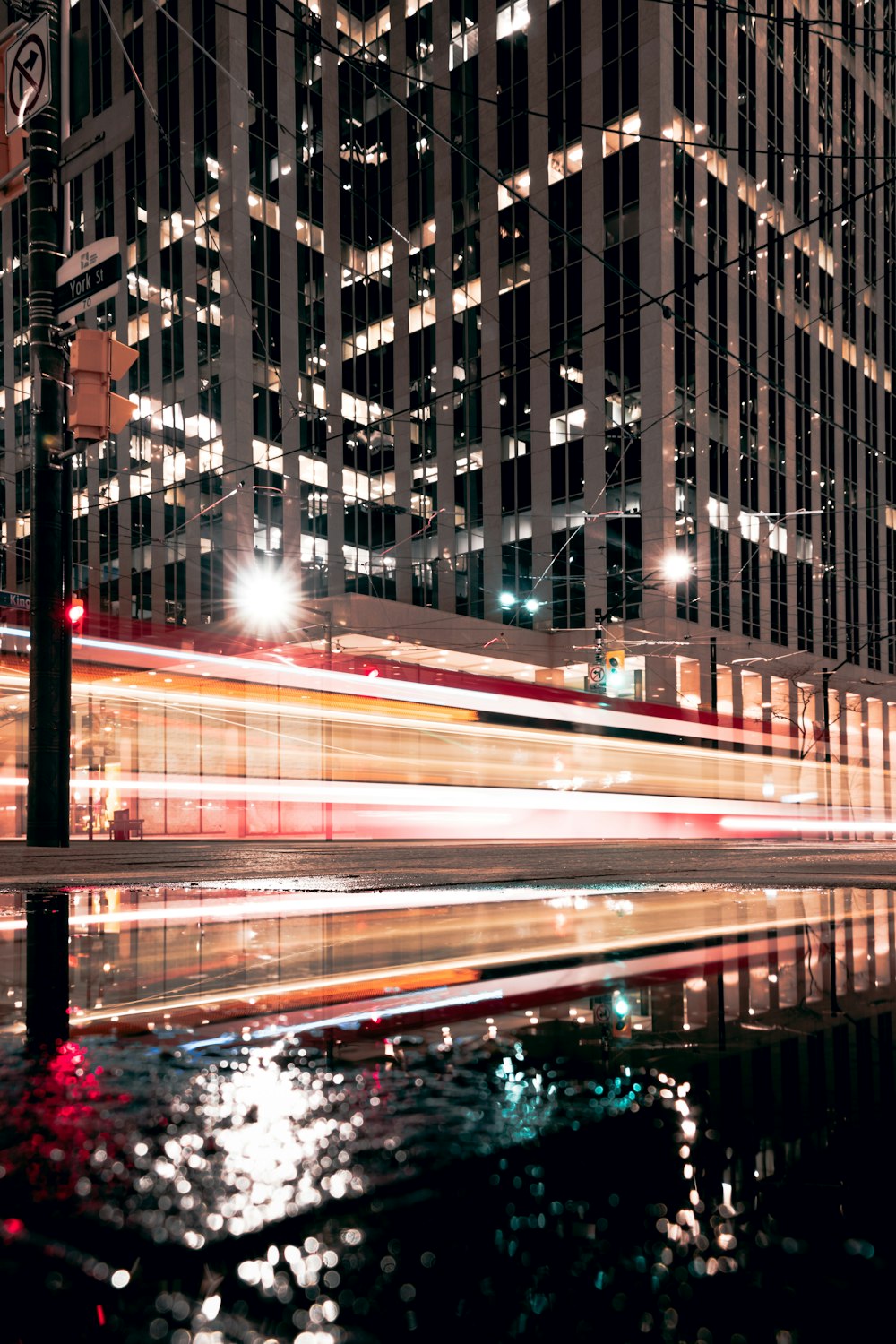 a city street at night with a train passing by