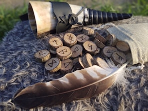 Close-up of wooden runes carved with intricate Celtic symbols resting on dark forest floor