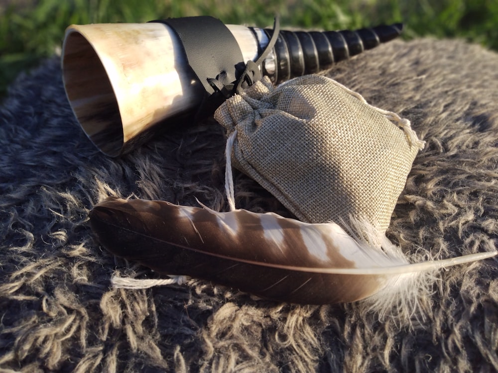 a feather, a hat, and a telescope on a blanket