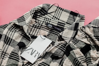 a label on a plaid shirt on a pink background
