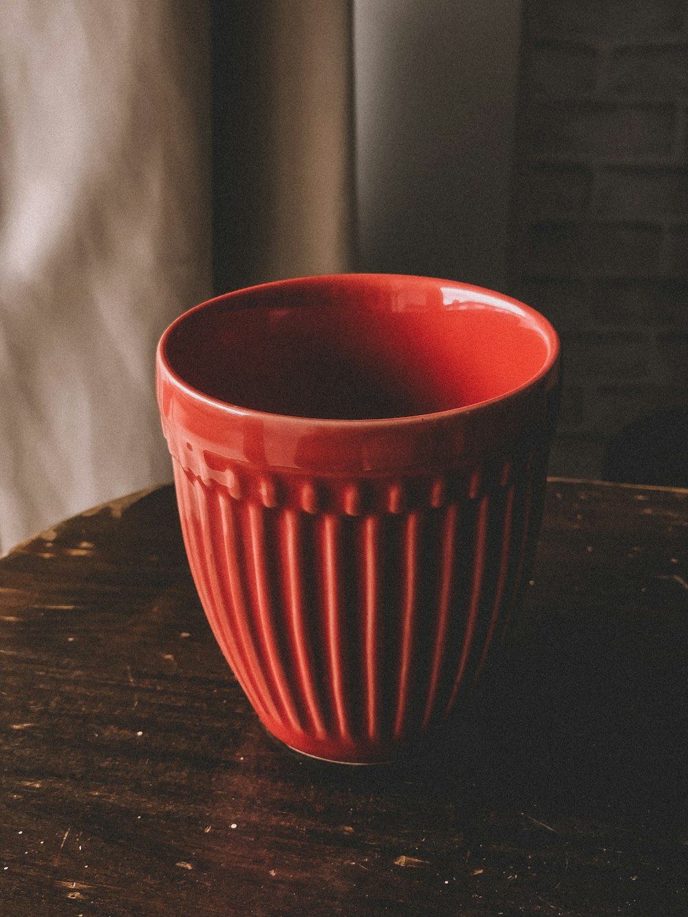 a red bowl sitting on top of a wooden table