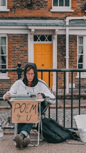 a person sitting in a chair holding a sign