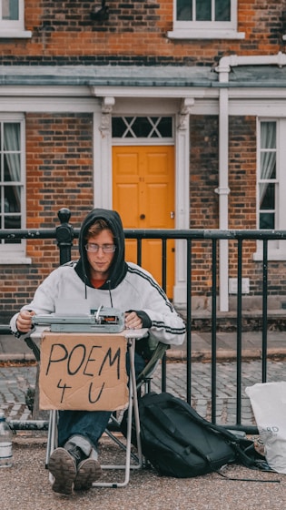 a person sitting in a chair holding a sign