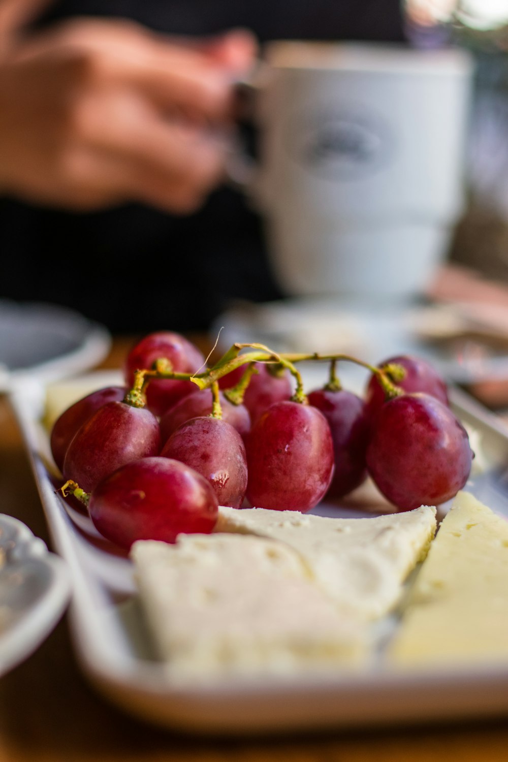 a plate of grapes and cheese on a table