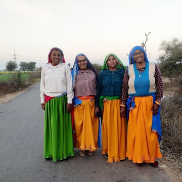 a group of women standing next to each other on a road