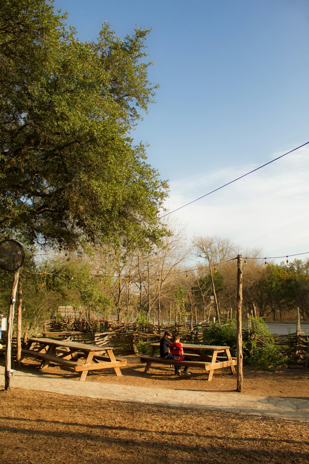 a couple of people sitting on top of a wooden bench