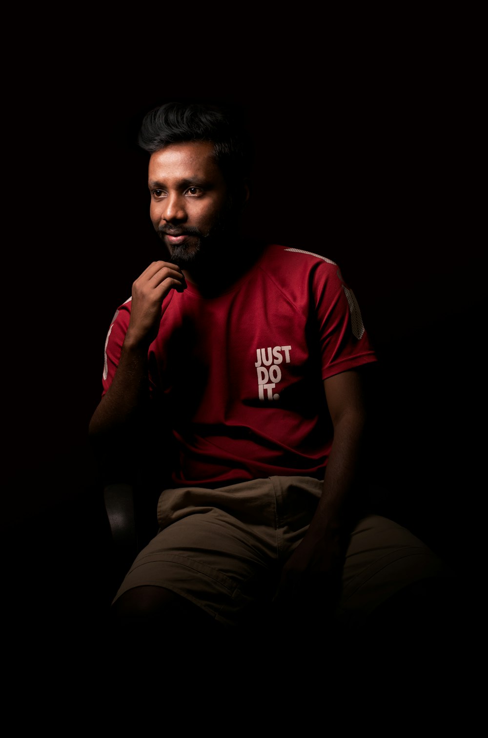 a man in a red shirt sitting in a chair