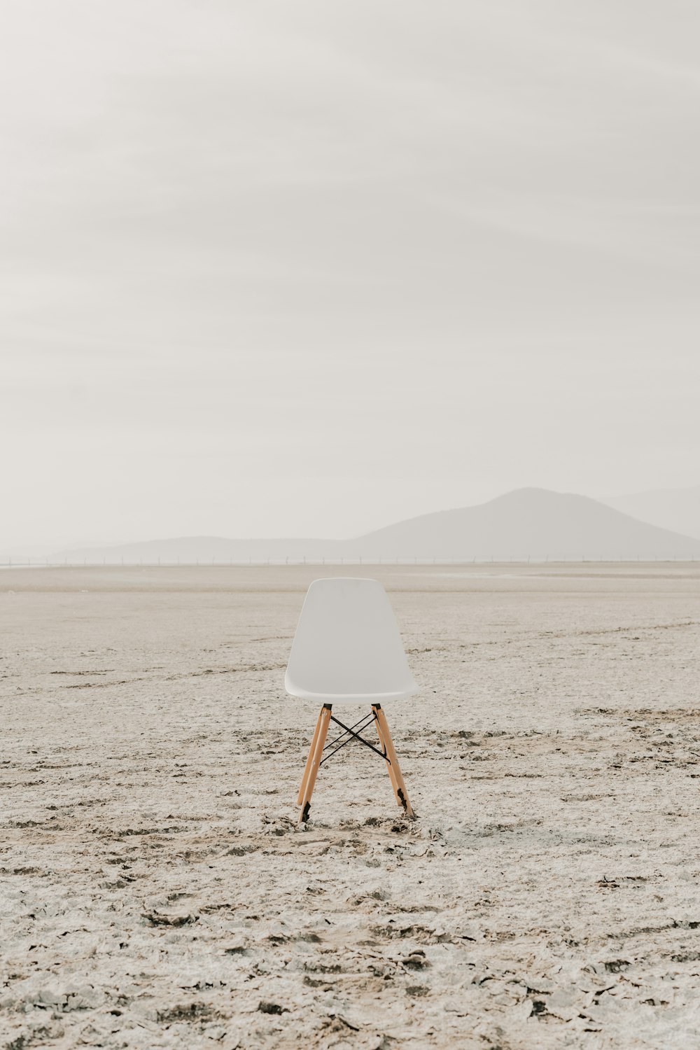 a white chair sitting on top of a sandy beach