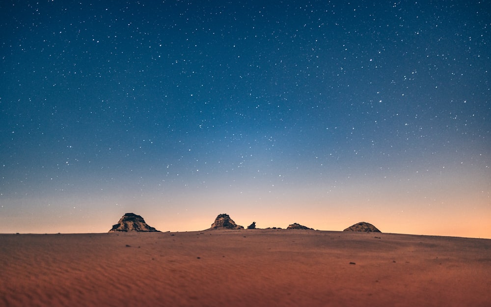 the night sky over the desert with stars in the sky
