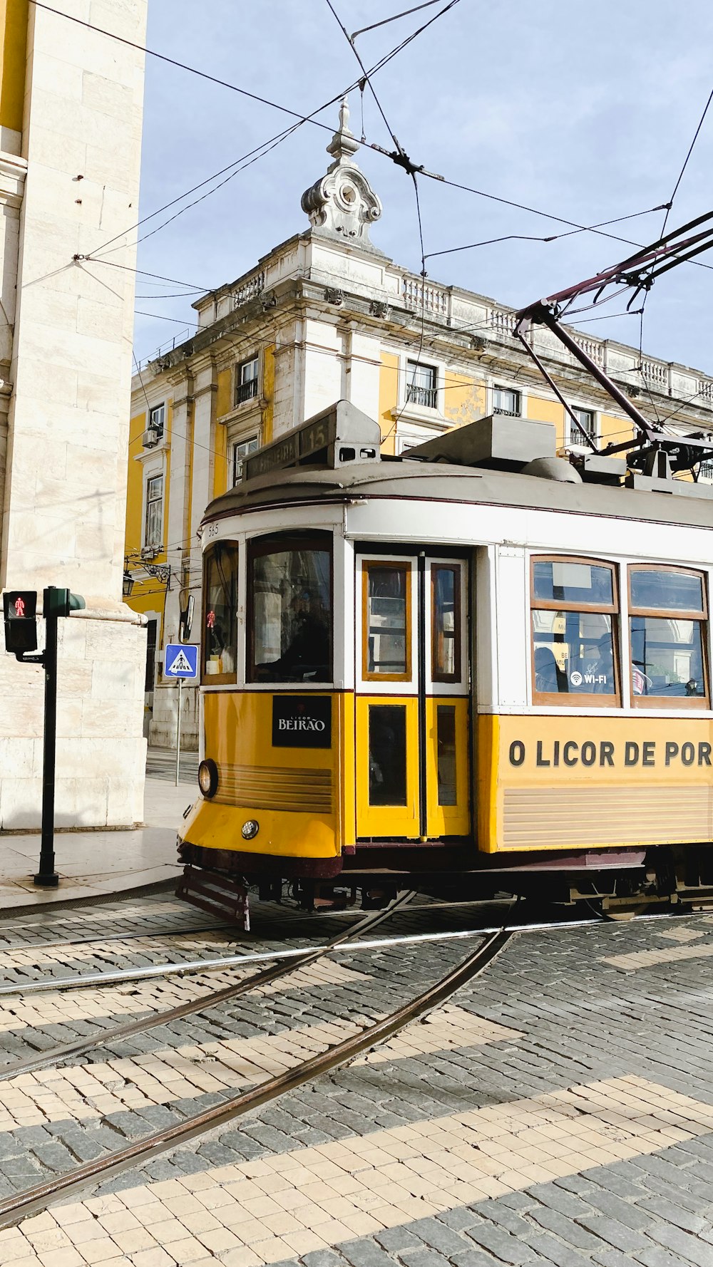 a yellow and white trolley on a city street