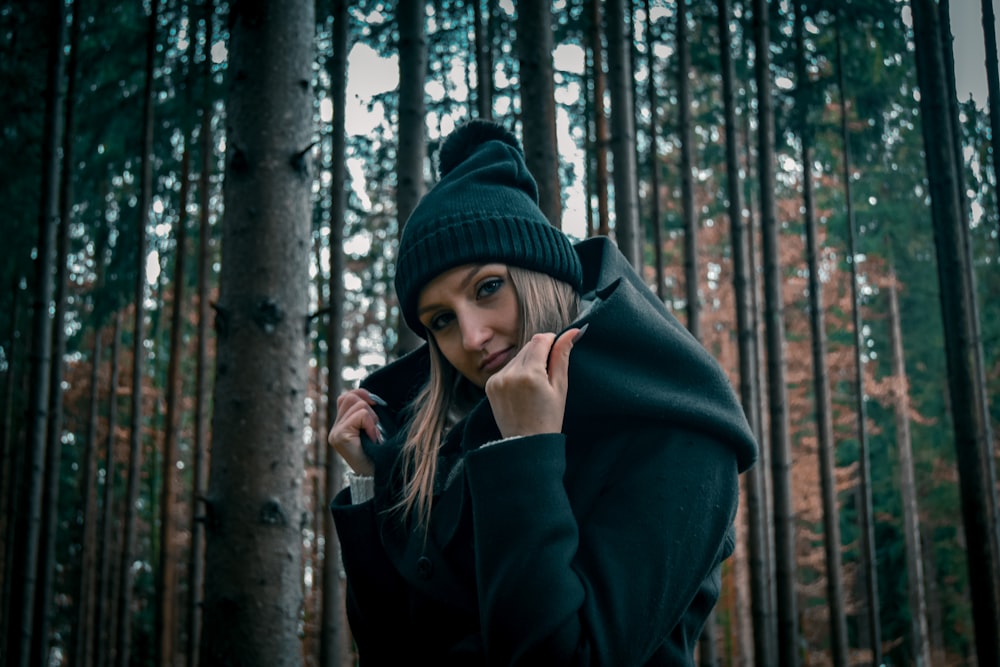 a woman wearing a black coat and a black hat