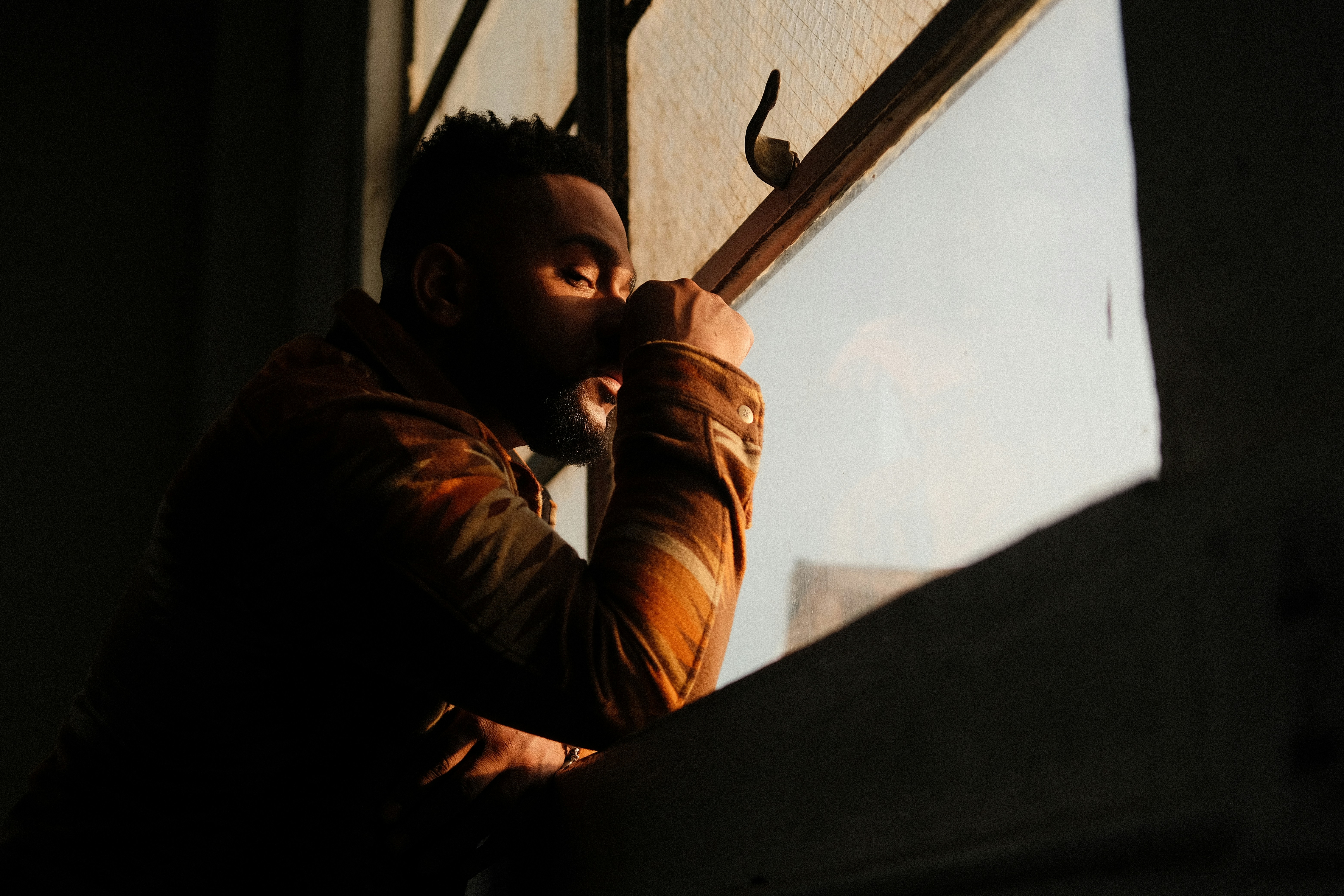 a man with a beard is holding a window handle