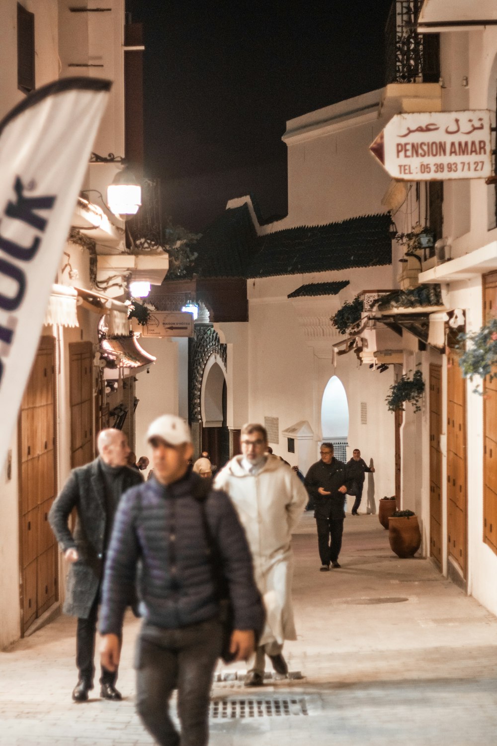 a group of people walking down a street at night