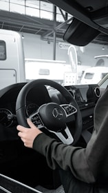 a person sitting in a car with a steering wheel