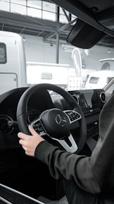 a person sitting in a car with a steering wheel