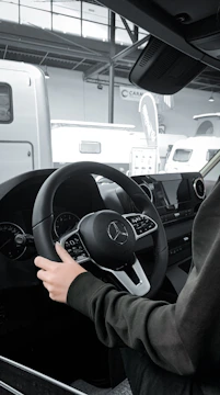 a person sitting in a car with a steering wheel